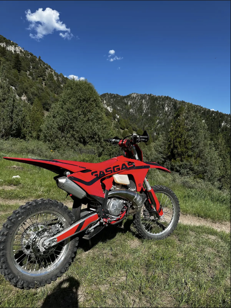 Dirt bike with custom Deviant Ink sticker wrap, styled for visual impact and resale appeal, parked in an open lot.